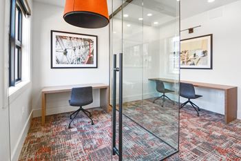 a conference room with glass walls and a red pendant light